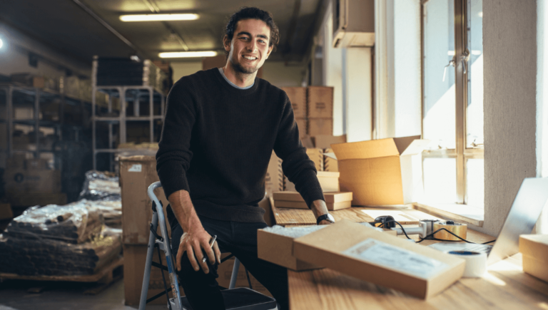 A Business Owner Sitting On A Chair In A Warehouse With An Optimized Business Listing Ask Us. Https://Websitedesignstlouis.com