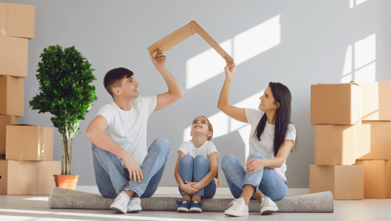 A Man And Woman Sitting On The Floor Holding A Cardboard Roof Above A Child For Life Insurance Website Https://Websitedesignstlouis.com/
