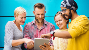 A Group Of People Looking At A Tablet 