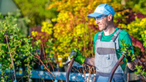 A Man In A Hat And Overalls Holding A Tool